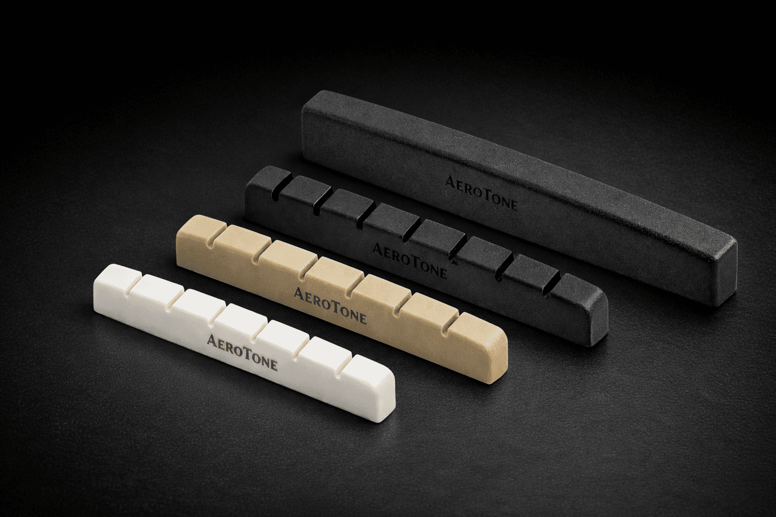 AeroTone guitar nuts in three materials — white, tan, and black — precision-machined aerospace-grade polymer blanks